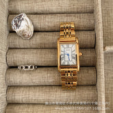 Reloj retro pequeño dorado con correa de acero de estilo antiguo.