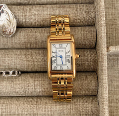 Reloj retro pequeño dorado con correa de acero de estilo antiguo.