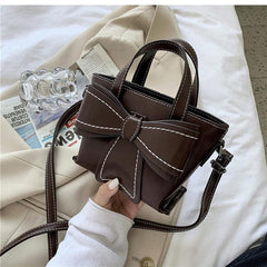 Bolso con lazo gigante y costuras en contraste