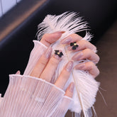 Uñas postizas redondeadas color nude con lazo negro