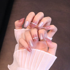 Uñas postizas redondeadas medianas en rosa claro con perlas y cristales