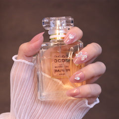 Uñas postizas redondeadas medianas en rosa claro con lazo y corazón iridiscentes