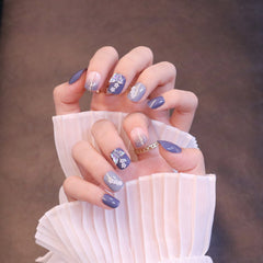 Kurze quadratische ovale lila Press-On-Nägel mit schillerndem Schmetterling und Blumen