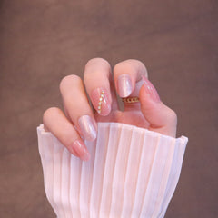 Uñas postizas redondeadas medianas en rosa claro con adornos de flores y cristales