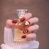 Uñas postizas rojas redondeadas medianas con adornos de flores y perlas