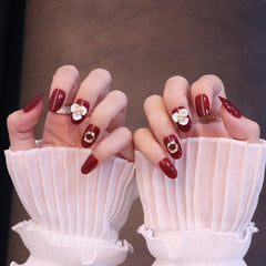 Uñas postizas rojas redondeadas medianas con adornos de flores y perlas