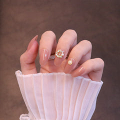 Mittelgroße, abgerundete, nudefarbene Press-On-Nägel mit Kranzanhänger und Perle