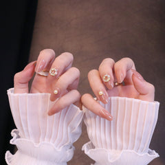 Mittelgroße, abgerundete, nudefarbene Press-On-Nägel mit Kranzanhänger und Perle