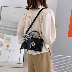 Kleine gesteppte Umhängetasche mit Blumenverschluss und geflochtenem Griff