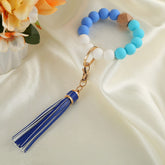 Pulsera con llavero de cuentas y borlas de colores
