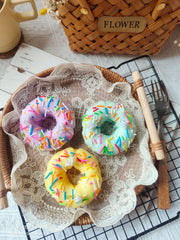 Dekorative Kerze mit Regenbogen-Streuseln und Donuts