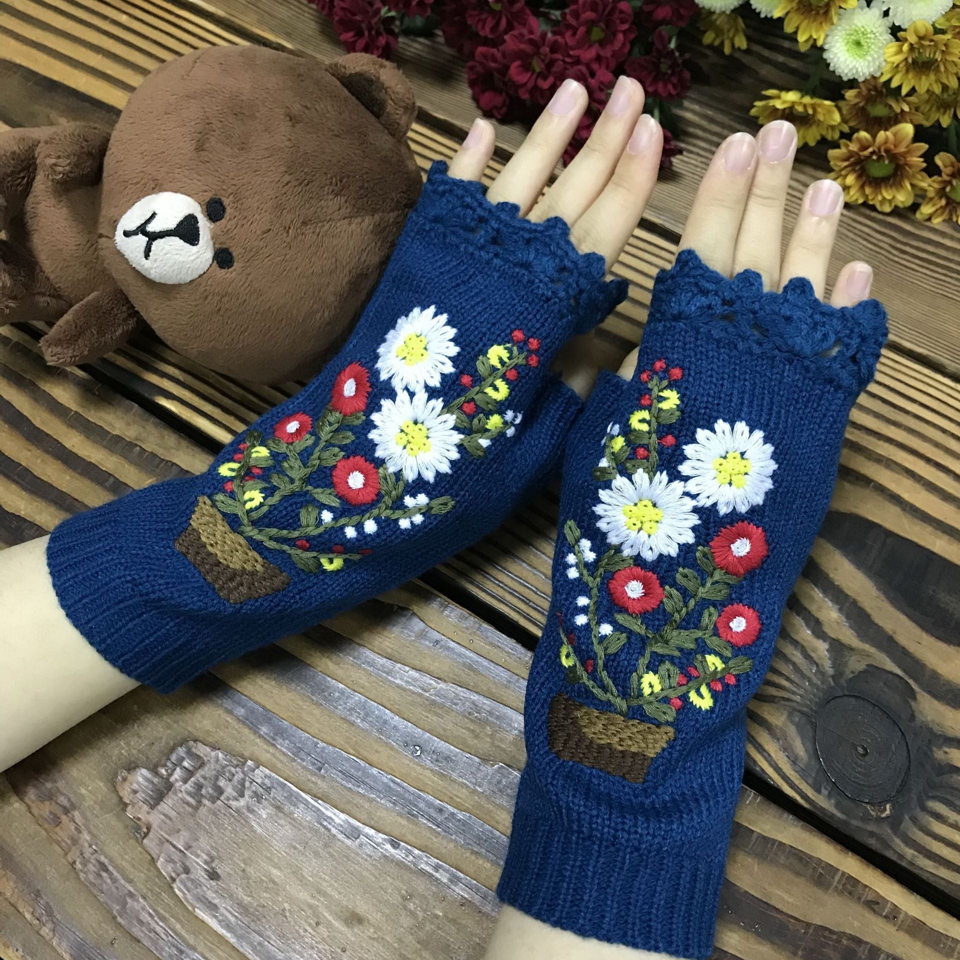 Lange warme Strickhandschuhe mit kleiner roter Blume im Topf