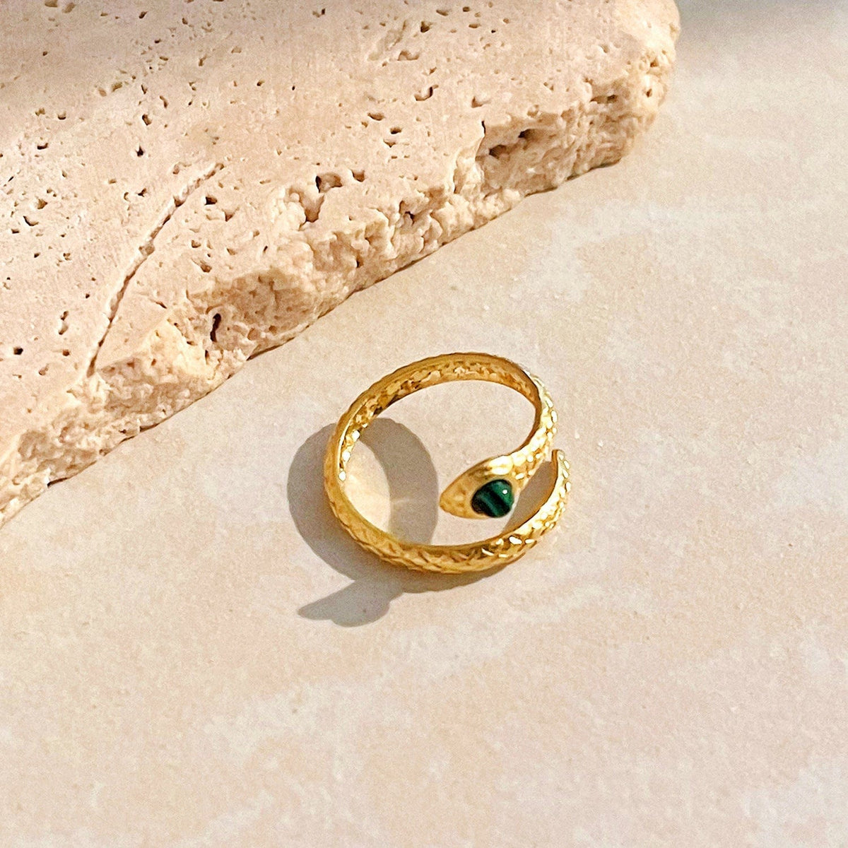 Anillo de serpiente retorcida de oro con cristal verde esmeralda